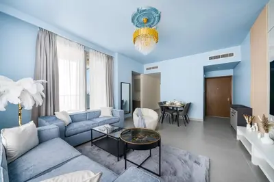 a living room with a blue couch and a table at KING 2BR LUX Apt-5mins Dubai Mall-Downtown Dubai in Dubai