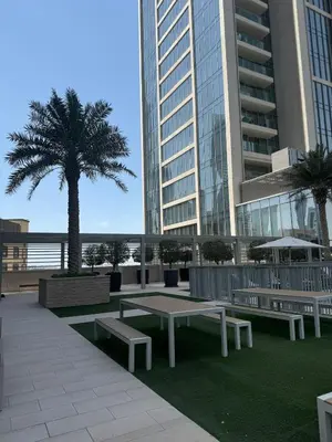a park with benches and a palm tree in front of a building at KING 2BR LUX Apt-5mins Dubai Mall-Downtown Dubai in Dubai