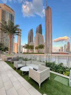 a rooftop patio with couches and tables and a city skyline at KING 2BR LUX Apt-5mins Dubai Mall-Downtown Dubai in Dubai