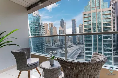 a balcony with two chairs and a view of a city at 2BR Breathtaking Waterfront Heart of Marina in Dubai