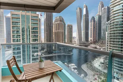 a balcony with a table and chairs and a view of a city at 2BR Breathtaking Waterfront Heart of Marina in Dubai