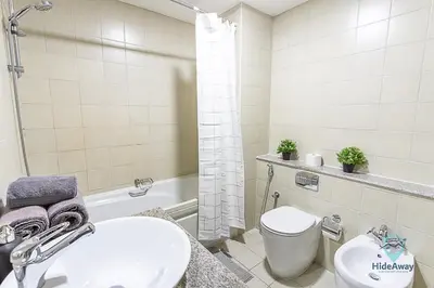 a bathroom with a sink and a toilet and a tub at 1BR Modern, Stylish l Mins to Beach l Dubai Marina in Dubai