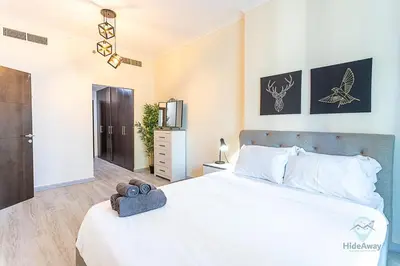 a bedroom with a large white bed and a television at 1BR Modern, Stylish l Mins to Beach l Dubai Marina in Dubai