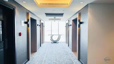 a hallway with doors and a table in the distance at Luxurious Studio in Damac Hills in Dubai