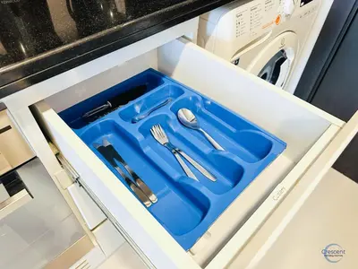 a drawer in a kitchen with a blue tray at Luxurious Studio in Damac Hills in Dubai