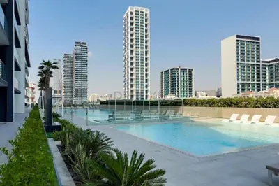 a large swimming pool in a city with tall buildings at Skyline-View 1BR with Balcony,Minutes to Downtown and Marina, Binghatti Onyx, Jumeirah Village Circle by Deluxe Holiday Homes in Dubai