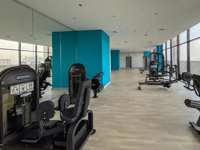 a gym with treadmills and machines in a building at Frank Porter - Azizi Riviera 16 in Dubai