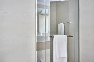 a bathroom with a shower with a white towel at Frank Porter - Azizi Riviera 16 in Dubai