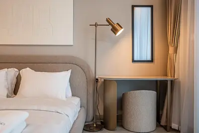 a bedroom with a bed and a desk with a lamp at Elegant 1BDR apartment in JVC in Dubai