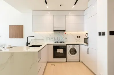 a white kitchen with a washing machine in it at High-Rise 1BR with Lake and City Views Easy Access to Downtown and Marina, Binghatti Onyx, Jumeirah Village Circle by Deluxe Holiday Homes in Dubai