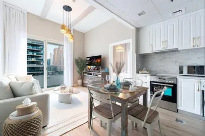 a kitchen and living room with a table and chairs at 1BR Beach House Vibes in Prime Marina Location in Dubai