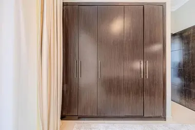 a closet with wooden cabinets in a room at 1 BD in Bay Central with the Iconic Marina Views in Dubai