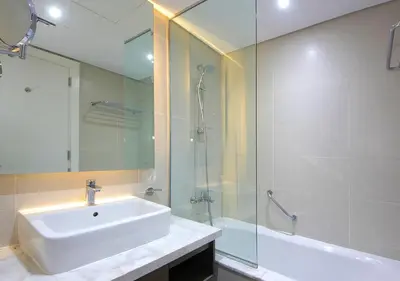 a bathroom with a sink and a glass shower at Luxury Damac Studio w Canal View Near Burj Khalifa in Dubai