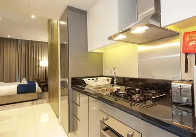 a kitchen with a stove and a bed in a room at Luxury Damac Studio w Canal View Near Burj Khalifa in Dubai