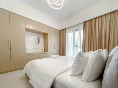 a white bedroom with a large bed and a window at Majestic Burj Khalifa View 2BR Premium Apartment By SBH in Dubai