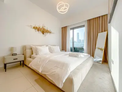 a white bedroom with a large bed and a window at Majestic Burj Khalifa View 2BR Premium Apartment By SBH in Dubai