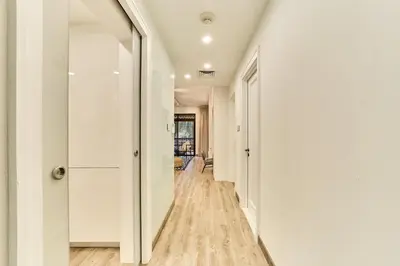 a hallway with white walls and a mirror at Luxury 1BR in Zaafran With Stunning Burj Khalifa View in Dubai