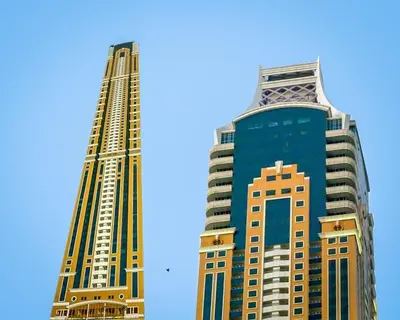 two tall buildings are standing next to each other at 1BR Tropical Vibes Near Skydiving and Beach! in Dubai