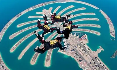 a group of people in suits flying over a city at 1 BR Blue Chic Dubai Marina, Steps to Beach! in Dubai