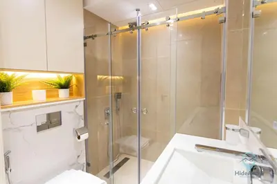 a bathroom with a shower and a toilet and a sink at Bright Modern 1BR Heart Of JLT Skyline Views in Dubai