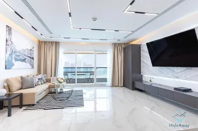 a living room with a couch and a tv at Bright Modern 1BR Heart Of JLT Skyline Views in Dubai