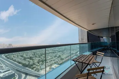 a balcony with two chairs and a table on a building at Bright Modern 1BR Heart Of JLT Skyline Views in Dubai