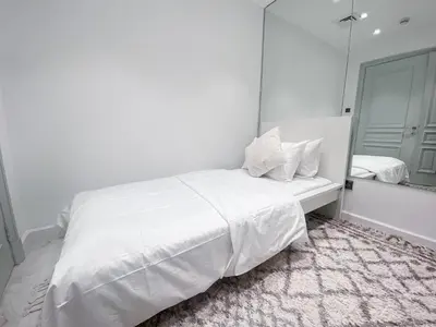 a white bedroom with a white bed and a mirror at Live the Burj Lifestyle in Timeless OldTown by SBH in Dubai