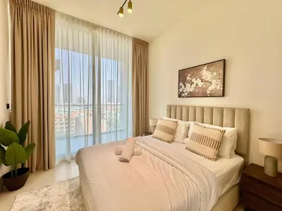 a bedroom with a large bed and a large window at Tranquil 1br Retreat Stylish Stay In Jvc in Dubai