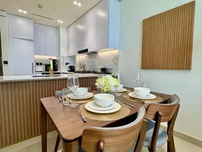 a dining room with a wooden table and chairs at Tranquil 1br Retreat Stylish Stay In Jvc in Dubai