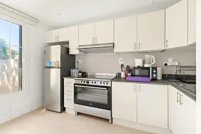 a kitchen with white cabinets and a stainless steel refrigerator at Silkhaus Luxe 2 BDR with Maid room in Springs 7 Villa 14 in Dubai
