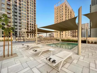 a pool with lounge chairs and a pavilion with buildings at Wonderful Stay at Collective 2- Unique in Dubai Hills - 5 min to Dubai Hills Mall - Brand New Luxury Apartments in Dubai