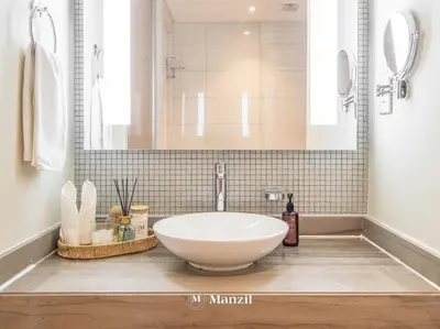 a bathroom with a white sink and a shower at Premium 2BR Apartment in Paramount Tower with City Skyline Views in Dubai
