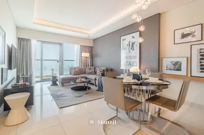 a living room with a dining table and a couch at Premium 2BR Apartment in Paramount Tower with City Skyline Views in Dubai