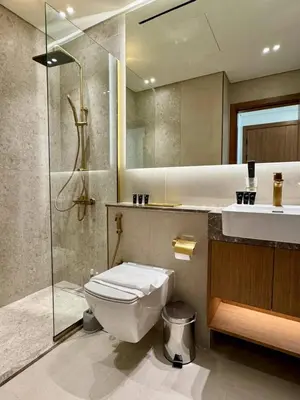 a bathroom with a toilet and a sink and a shower at Modern 1br W Calm Interiors Jvc Dubai in Dubai