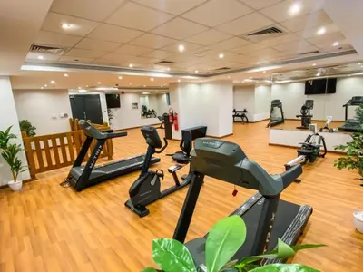 a gym with treadmills and ellipticals in a room at Elite Downtown Stay with Gym, Pool near Dubai Mall in Dubai