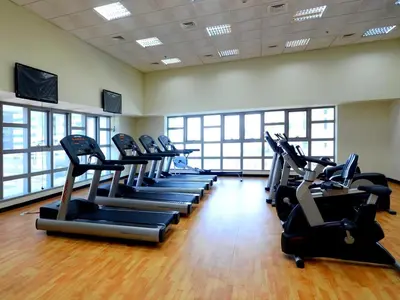 a gym with a row of cardio machines in a room at 1BR Cool Vibes Pool Views Dubai Marina in Dubai