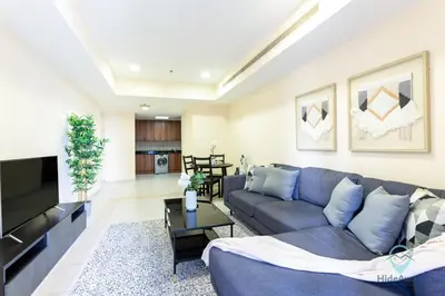 a living room with a couch and a tv at 1BR Cool Vibes Pool Views Dubai Marina in Dubai