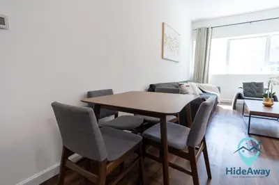 a living room with a wooden table and chairs at 1BR Cozy and Bright Dubai Marina in Dubai