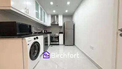 a kitchen with a refrigerator and a washer and dryer at Spacious and Bright Retreat in JBR in Dubai