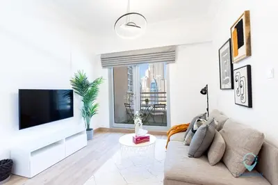 a living room with a couch and a tv at 1BR Marina View Rooftop Pool Dubai Marina in Dubai