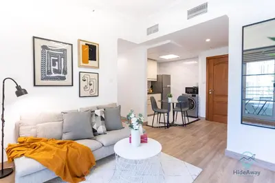 a living room with a couch and a table at 1BR Marina View Rooftop Pool Dubai Marina in Dubai