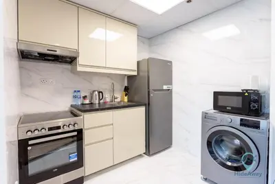 a kitchen with a refrigerator and a washing machine at 1BR Marina View Rooftop Pool Dubai Marina in Dubai