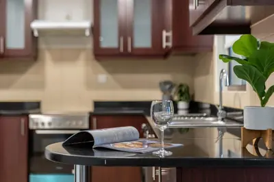 a kitchen counter with a plate of pizza and a wine glass at Enchanting Stay in JBR Near The Beach in Dubai