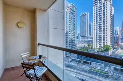 a balcony with a table and chairs and a view of the city at Enchanting Stay in JBR Near The Beach in Dubai