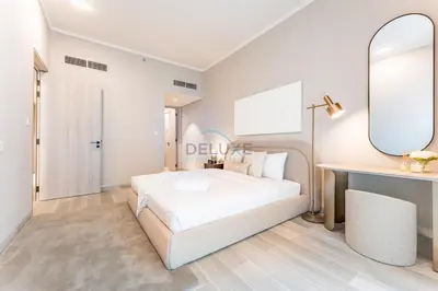 a bedroom with a white bed and a mirror at City Views 1BR with Balcony Near Mall, Concept 7 Residences, Jumeirah Village Circle by Deluxe Holiday Homes in Dubai