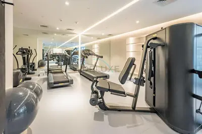 a gym with a row of tread machines at City Views 1BR with Balcony Near Mall, Concept 7 Residences, Jumeirah Village Circle by Deluxe Holiday Homes in Dubai