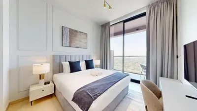 a bedroom with a bed and a large window at Binghatti Onyx - Upgraded One Bedroom in JVC in Dubai