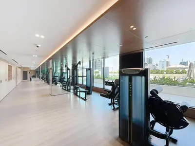 a fitness room with a row of exercise equipment at Binghatti Onyx - Upgraded One Bedroom in JVC in Dubai
