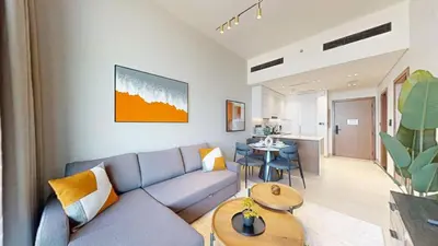 a living room with a blue couch and a table at Binghatti Onyx - Upgraded One Bedroom in JVC in Dubai