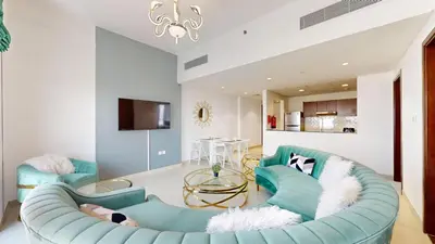 a living room with a blue couch and a table at Vacationer I Exclusive 2 Bedroom I Breathtaking Skyline & City Views I Afnan 1 - IMPZ in Dubai